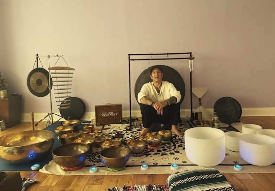 Michael McCullough in a red-lit sound healing studio
